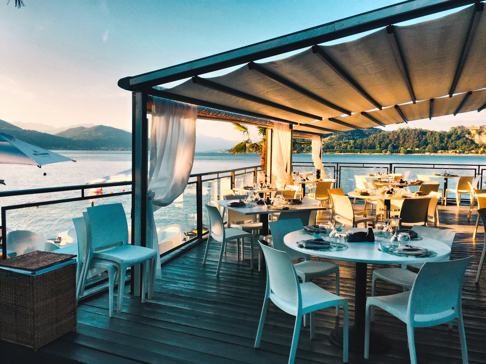 Golden-hour terrace with curtains and long tables set for a celebration